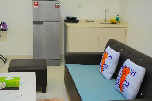 a kitchen with a couch with two pillows and a refrigerator at 3 Towers Jalan Ampang By Serenity Vacation Homes in Kuala Lumpur