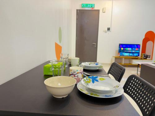a table with plates and bowls on top of it at 3 Towers Jalan Ampang By Serenity Vacation Homes in Kuala Lumpur