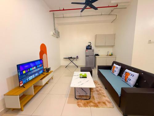 a living room with a couch and a tv at 3 Towers Jalan Ampang By Serenity Vacation Homes in Kuala Lumpur