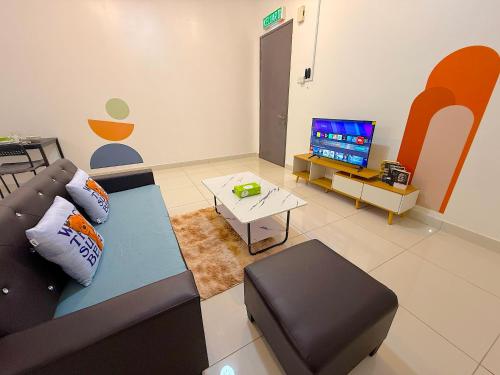 a living room with a couch and a tv at 3 Towers Jalan Ampang By Serenity Vacation Homes in Kuala Lumpur