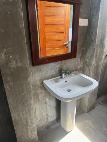 a bathroom with a sink and a mirror at Steps Garden Resort in Negombo