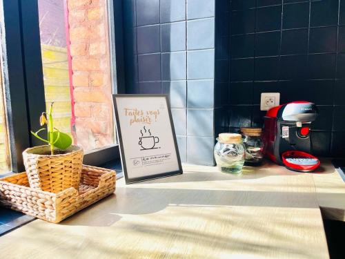 a table with a sign and a coffee maker on it at La Petite Maison Solognote, au pied du Château in La Ferté-Saint-Aubin