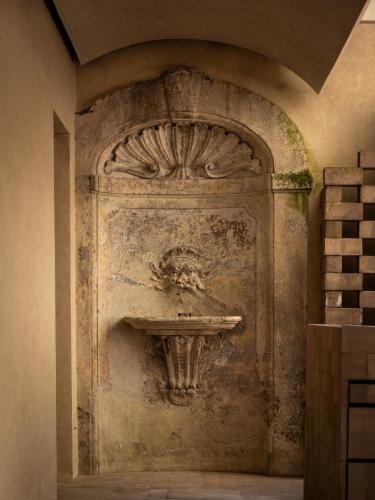 a stone wall with a sink in a room at Nomos Hotel in Rome