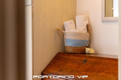 a basket of towels sitting on top of a wooden table at Vela by PortofinoVip in Portofino