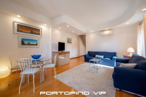 a living room with a blue couch and a table at Vela by PortofinoVip in Portofino