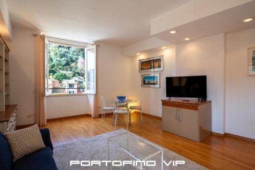 a living room with a tv and a table at Vela by PortofinoVip in Portofino
