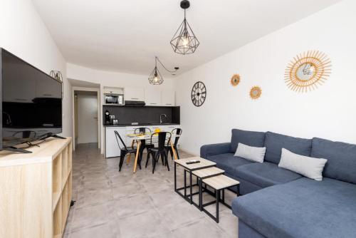 un salon avec un canapé bleu et une table dans l'établissement L'atelier De La Cite - Parking Gratuit Sécurisé, à Carcassonne