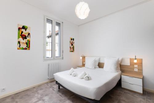 - une chambre dotée d'un lit blanc avec deux animaux rembourrés dans l'établissement L'atelier De La Cite - Parking Gratuit Sécurisé, à Carcassonne