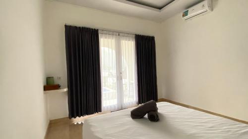 um quarto com uma cama e uma janela grande em Lake Side retreat em Kintamani