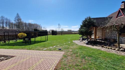 a backyard with a fence and a grass field at Harcówka in Miękisz Nowy