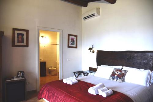 a bedroom with a bed with two towels on it at La Grande Via, ospitalità in Maremma in Montemerano