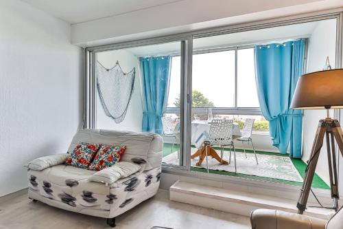un salon avec une chaise et une grande fenêtre dans l'établissement Marina - Joli studio face à l'océan, à Saint-Jean-de-Monts