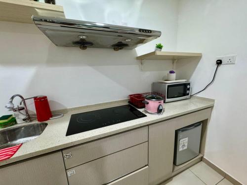 a small kitchen with a sink and a microwave at SA Sutera Avenue Homestay Opposite Imago KK in Kota Kinabalu