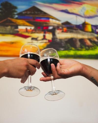 two people are holding glasses of red wine at Naya Gaun Eco Resort in Pokhara
