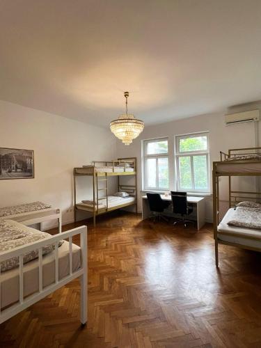 a room with several bunk beds and a chandelier at Rooms Miklošičeva in Ljubljana