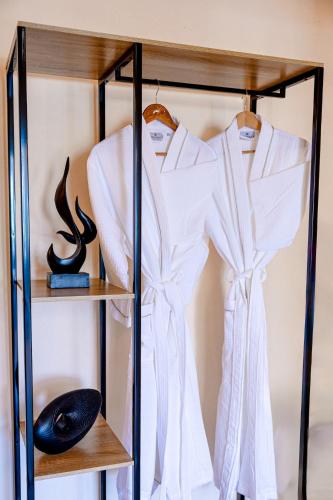a shelf with a white shirt and a dress on it at Parastia Luxury Villa Santorini - Private Jacuzzi in Éxo Goniá