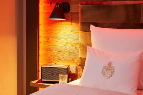 a bedroom with a bed with a clock and a lamp at Best Western Plus Hotel Erb in Parsdorf