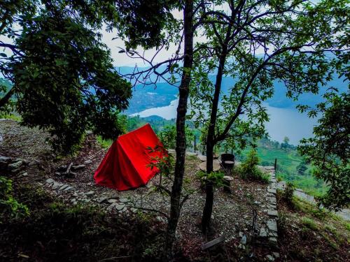 a red tent sitting on the side of a hill at Naya Gaun Eco Resort in Pokhara