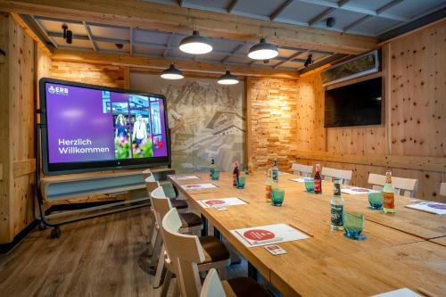 a conference room with a long table and a large screen at Best Western Plus Hotel Erb in Parsdorf