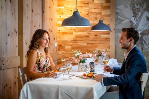 a man and woman sitting at a table in a restaurant at Best Western Plus Hotel Erb in Parsdorf
