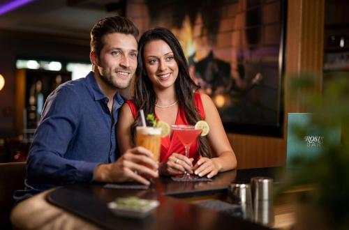 a man and woman sitting at a table with drinks at Best Western Plus Hotel Erb in Parsdorf