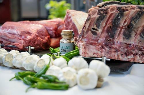 a table with meat and a bottle of jamrilril next to vegetables at Best Western Plus Hotel Erb in Parsdorf