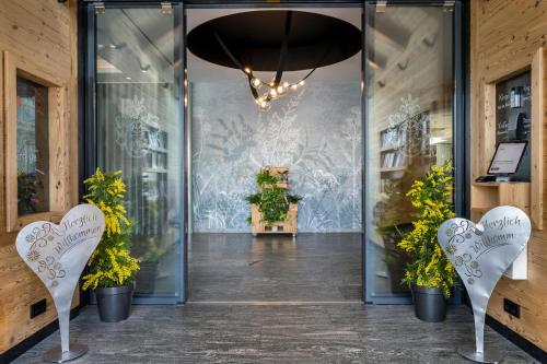 a lobby with a glass door with plants in it at Best Western Plus Hotel Erb in Parsdorf