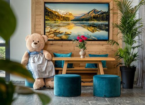 a teddy bear sitting next to a table with a painting at Best Western Plus Hotel Erb in Parsdorf