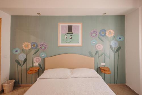 a bedroom with a bed with flowers on the wall at La Casa Di Pinocchio in Enna