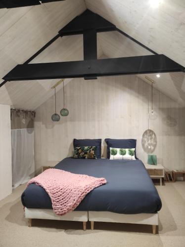 - une chambre avec un grand lit bleu dans l'établissement La Ville Es Riez Chambre d'hôtes, à Corseul