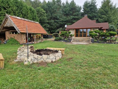 a house with a stone fire pit in the yard at Harcówka in Miękisz Nowy