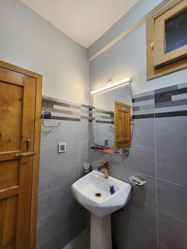 a bathroom with a white sink and a mirror at Dream Palace Hotel Rakaposhi Nagar in Gilgit