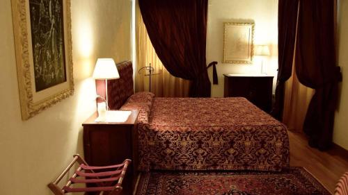 a bedroom with a bed and a lamp and curtains at La Torre Hotel in Moie