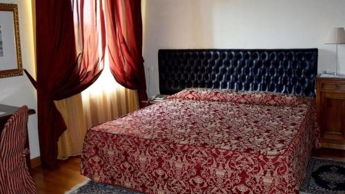 a bedroom with a bed with a red blanket at La Torre Hotel in Moie