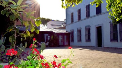 a courtyard with red flowers in front of a building at La Torre Hotel in Moie