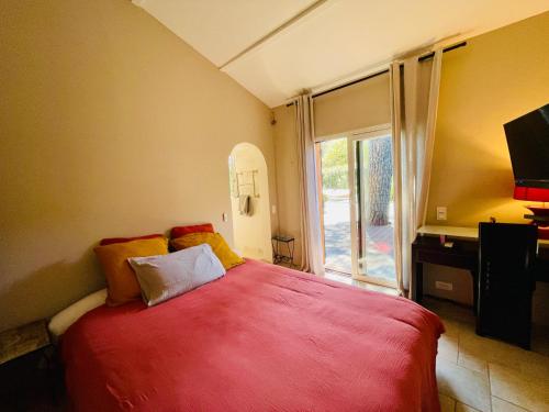 - une chambre avec un grand lit rouge et une fenêtre dans l'établissement St Tropez 7km, Villa Gassinette, à Gassin