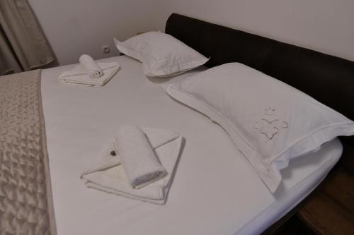 a bed with white sheets and towels on it at Palomino house in Sinj