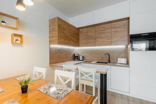 a kitchen with a table and chairs and a counter at Seaside Sun Seasons 24 Apartments in Pogorzelica with Parking by Noclegi Renters in Pogorzelica