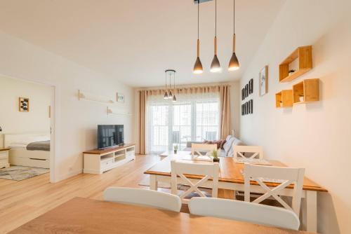 a dining room and living room with a table and chairs at Seaside Sun Seasons 24 Apartments in Pogorzelica with Parking by Noclegi Renters in Pogorzelica