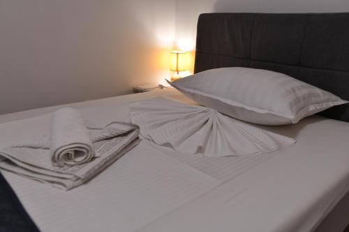 a bed with two towels and a pillow and a blanket at Palomino house in Sinj