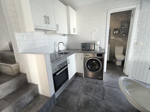 a kitchen with a washing machine and a sink at Casa Nentis in Mucientes