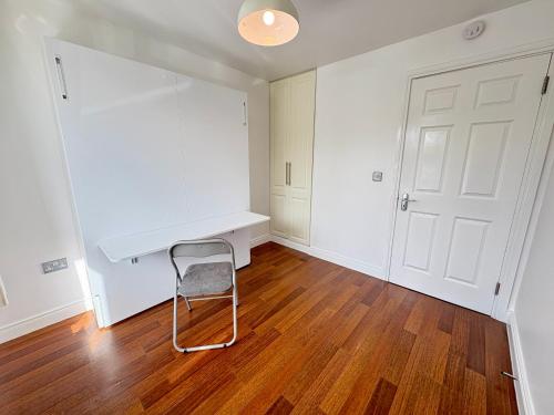 an empty room with a white desk and a chair at Family Friendly Mullingar Self Catering Apartment on Park Hotel Grounds in Mullingar