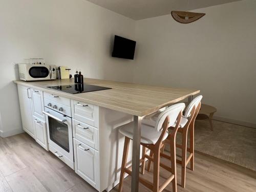 a kitchen with a table with chairs and a microwave at La Millière - Piscine & Campagne - D'Elbée in Le Poiré-sur-Vie