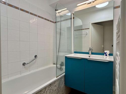 La salle de bains est pourvue d'une armoire bleue, d'une baignoire et d'un lavabo. dans l'établissement Appartement 2 pièces Résidence Mer et Golf au Port d'Argelès sur Mer AR045-C64, à Argelès-sur-Mer