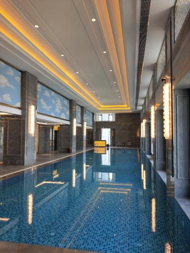 a large swimming pool in a building with a ceiling at Ramada Plaza by Wyndham Wenzhou in Wenzhou