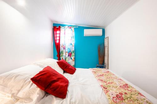 a bedroom with a bed with red pillows on it at Gîte Dalina in Saint-François