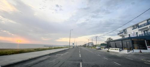 an empty street with a building and the ocean at istanbul Airport Kumsal Otel in Arnavutköy