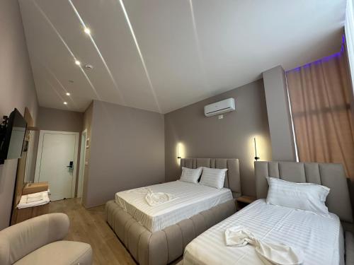 a hotel room with two beds and a chair at Luxury Hotel By Gjyshi in Qerrexhias