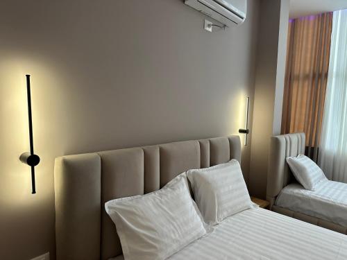a bedroom with a bed with white sheets and pillows at Luxury Hotel By Gjyshi in Qerrexhias