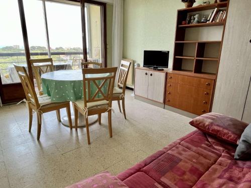 un salon avec une table, des chaises et une télévision dans l'établissement Studio cabine 4 couchages ARGELES SUR MER AR200-084, à Argelès-sur-Mer